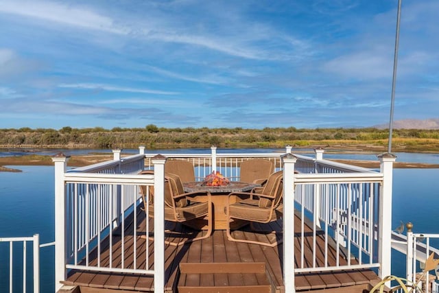 wooden deck with a water view and a fire pit