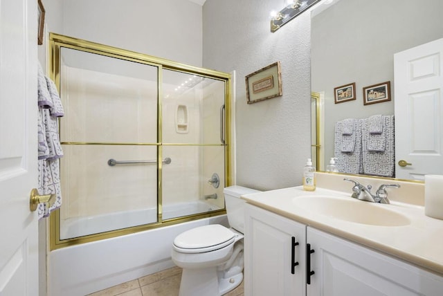 full bathroom with tile patterned flooring, vanity, enclosed tub / shower combo, and toilet