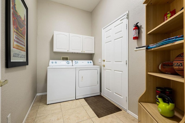 laundry room featuring separate washer and dryer, light tile patterned floors, and cabinets