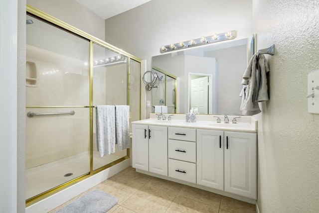 bathroom featuring tile patterned floors, a shower with door, and vanity