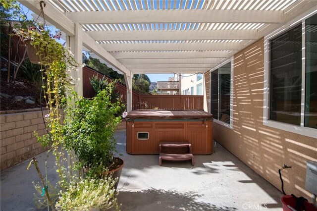 view of patio / terrace featuring a pergola and a hot tub