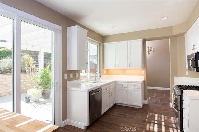 kitchen featuring appliances with stainless steel finishes, dark hardwood / wood-style flooring, white cabinetry, and a wealth of natural light