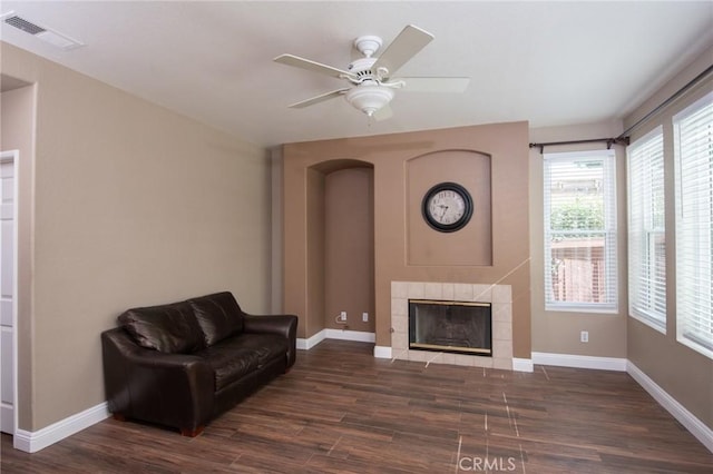 living area featuring a fireplace, dark hardwood / wood-style floors, plenty of natural light, and ceiling fan