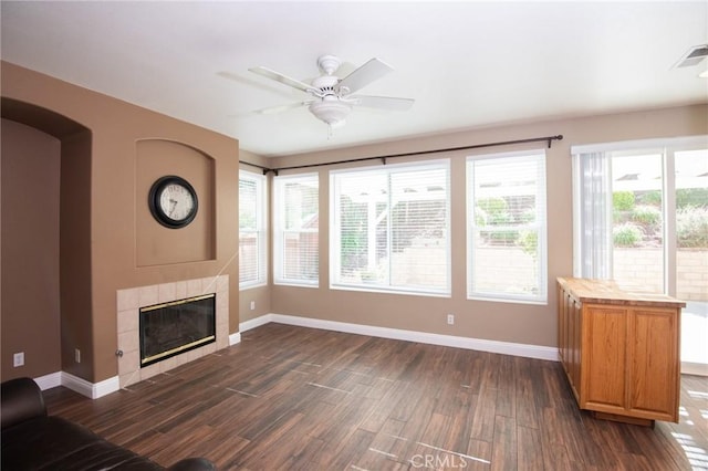 unfurnished living room with dark hardwood / wood-style floors, ceiling fan, and a tile fireplace