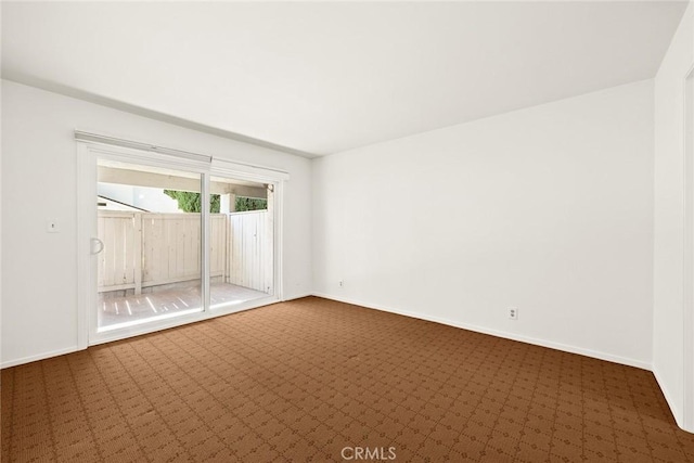 spare room featuring dark colored carpet