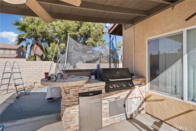 view of patio featuring exterior bar, an outdoor kitchen, and a grill