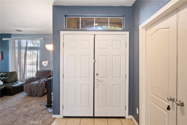 foyer entrance featuring light carpet