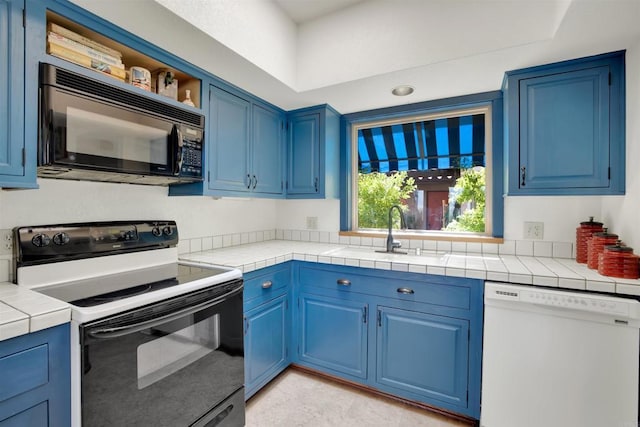 kitchen featuring sink, blue cabinetry, range with electric stovetop, dishwasher, and tile counters