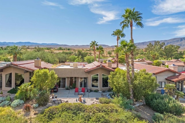 view of front of property with a mountain view and a patio