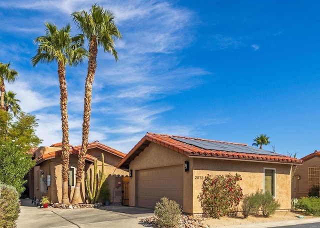 view of front of property featuring solar panels and a garage