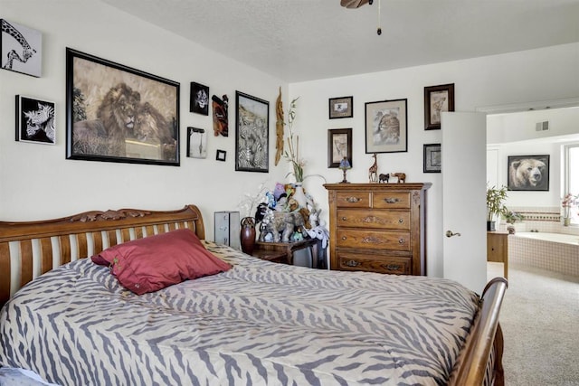 carpeted bedroom with connected bathroom and a textured ceiling