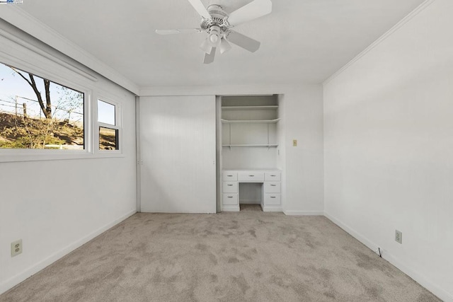 unfurnished bedroom featuring ceiling fan, ornamental molding, light carpet, and a closet