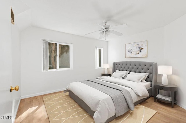 bedroom with hardwood / wood-style flooring, ceiling fan, and vaulted ceiling