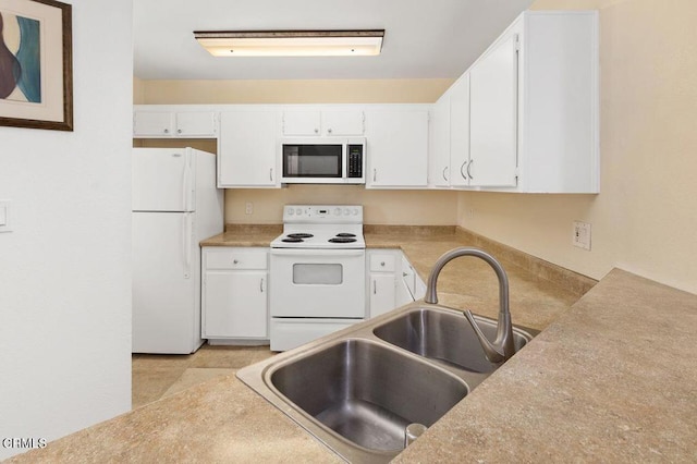 kitchen with white appliances, white cabinetry, and sink