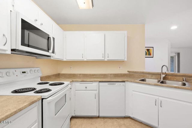 kitchen featuring white cabinets, light tile patterned flooring, white appliances, and sink