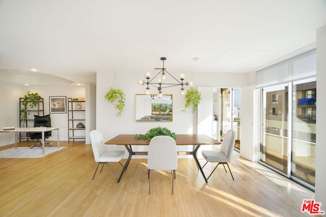 dining room with light hardwood / wood-style floors and a notable chandelier