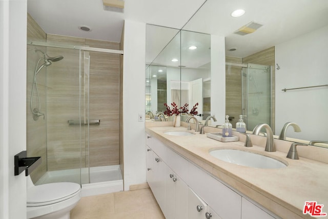 bathroom with toilet, vanity, tile patterned floors, and an enclosed shower