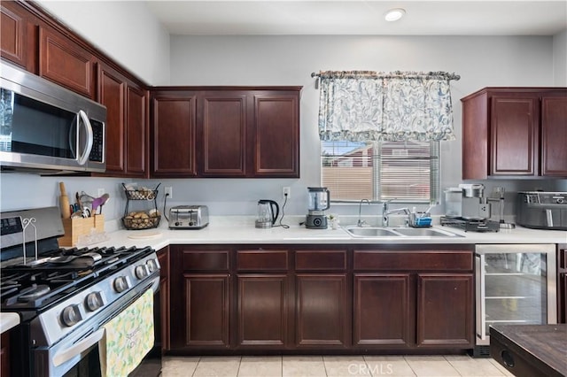 kitchen featuring beverage cooler, light tile patterned floors, sink, and appliances with stainless steel finishes