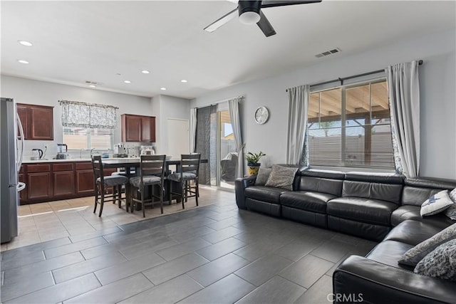 tiled living room with ceiling fan