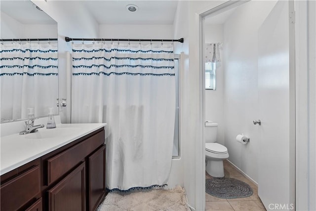 bathroom with tile patterned floors, vanity, toilet, and walk in shower