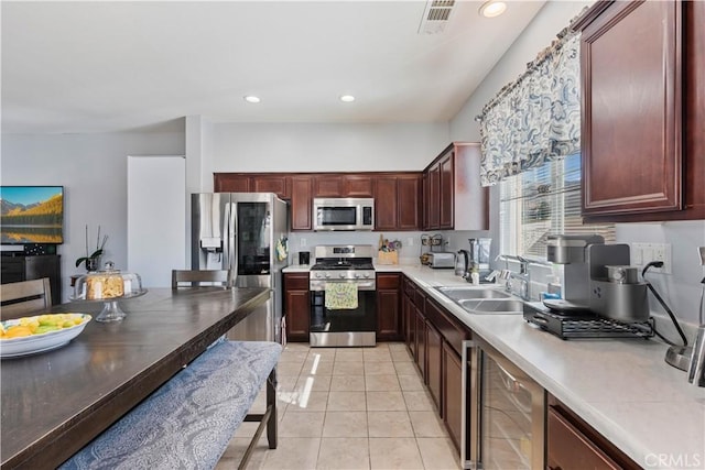 kitchen with wine cooler, sink, light tile patterned floors, and appliances with stainless steel finishes