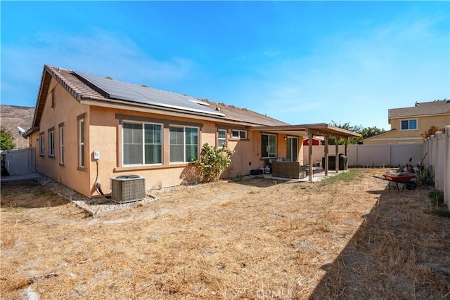 back of property with solar panels, cooling unit, an outdoor hangout area, and a patio