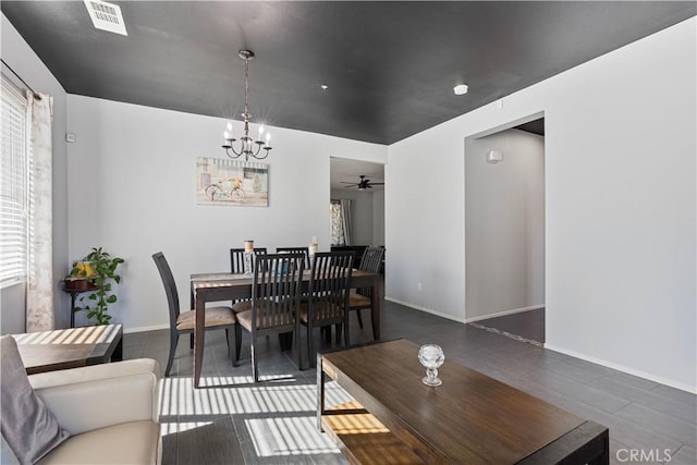 dining area featuring dark hardwood / wood-style flooring and ceiling fan with notable chandelier