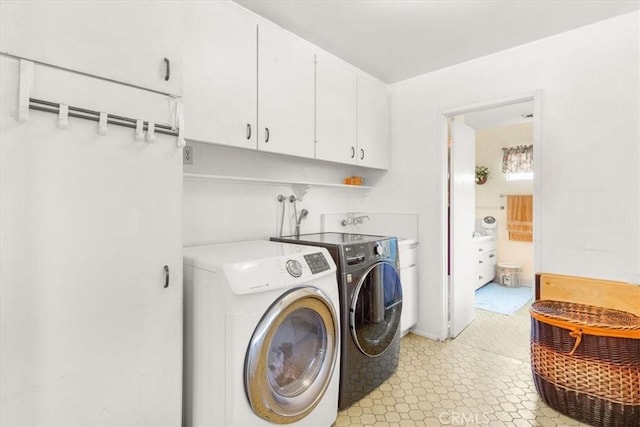 laundry room featuring cabinets and washing machine and clothes dryer