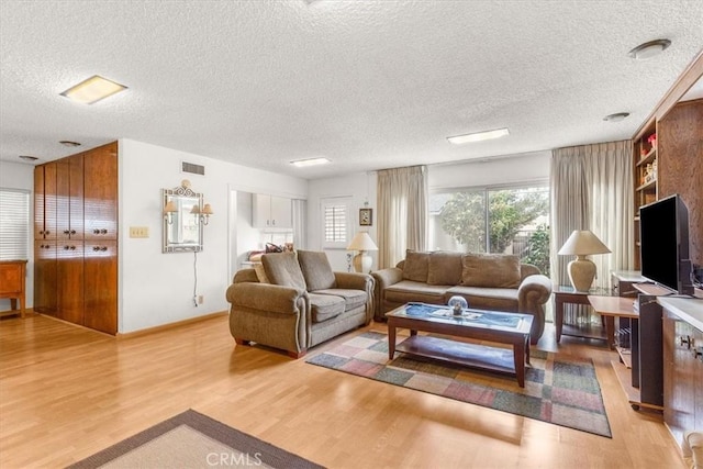 living room featuring a textured ceiling and light hardwood / wood-style flooring