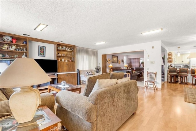 living room featuring a textured ceiling and light hardwood / wood-style flooring