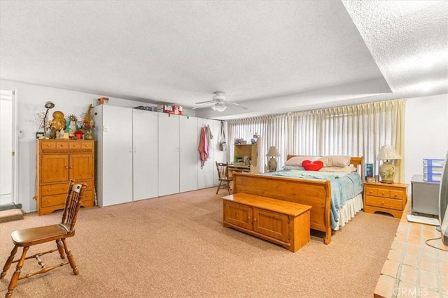 carpeted bedroom with ceiling fan and a textured ceiling