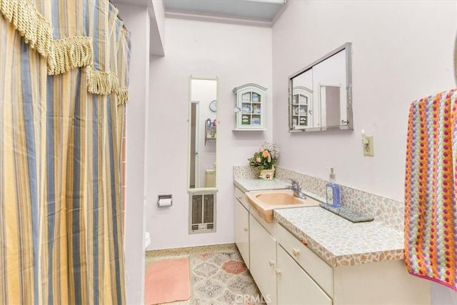 bathroom featuring tile patterned floors, vanity, heating unit, and toilet