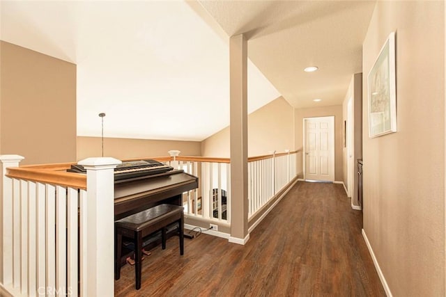 corridor with vaulted ceiling and dark wood-type flooring