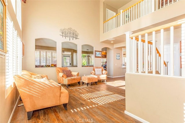 living room featuring a towering ceiling and hardwood / wood-style flooring