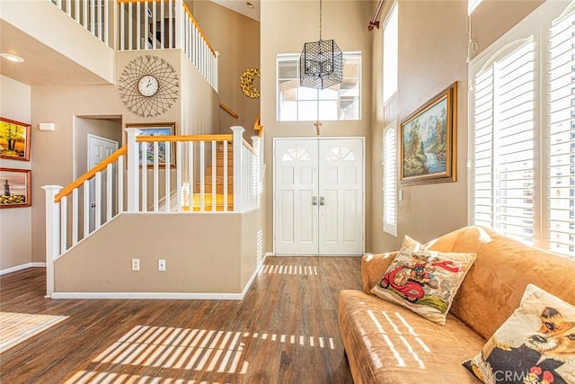 entryway with plenty of natural light, dark hardwood / wood-style floors, and a towering ceiling