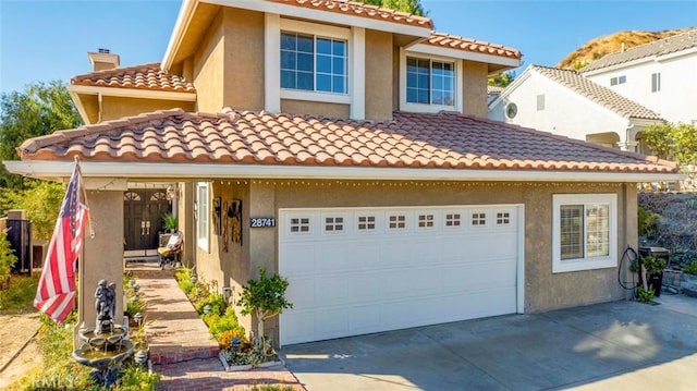 mediterranean / spanish home featuring a garage