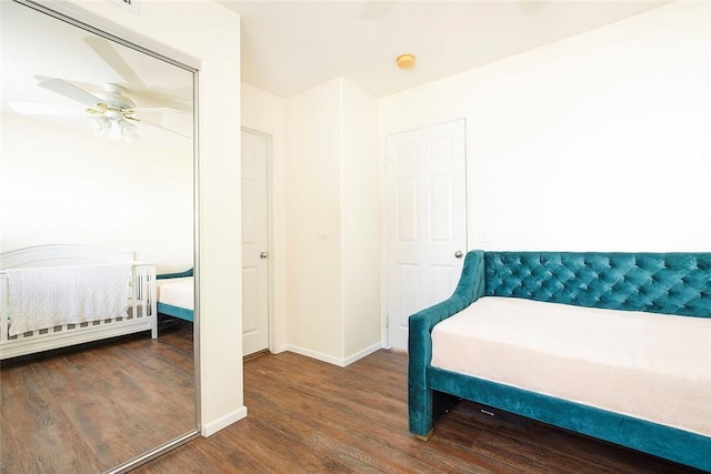 bedroom with dark hardwood / wood-style flooring, a closet, and ceiling fan