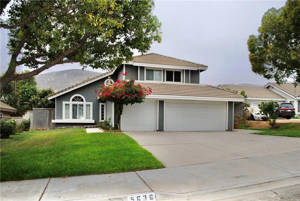 view of front of property with a mountain view, a front yard, and a garage