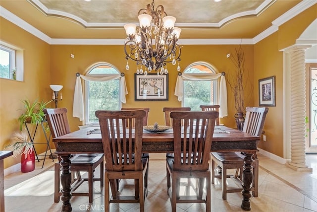 dining area with a healthy amount of sunlight, a tray ceiling, and ornate columns