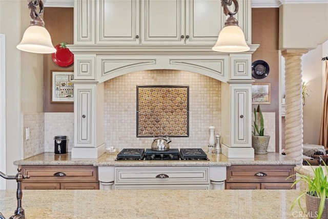 kitchen featuring light stone countertops, black gas stovetop, tasteful backsplash, decorative columns, and cream cabinetry