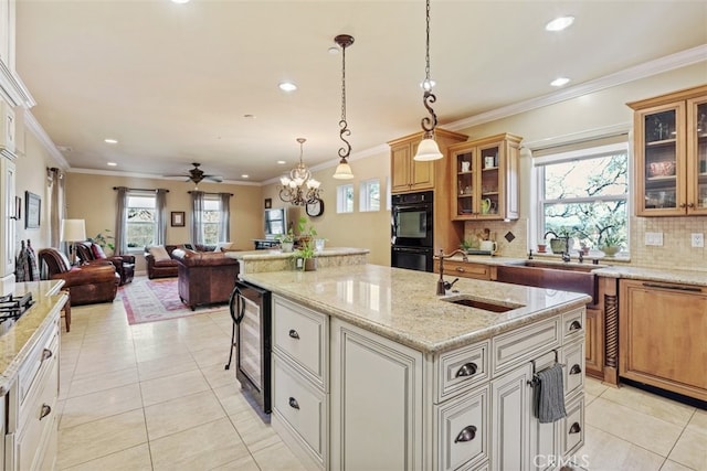 kitchen with sink, decorative light fixtures, light tile patterned flooring, a kitchen island with sink, and black double oven