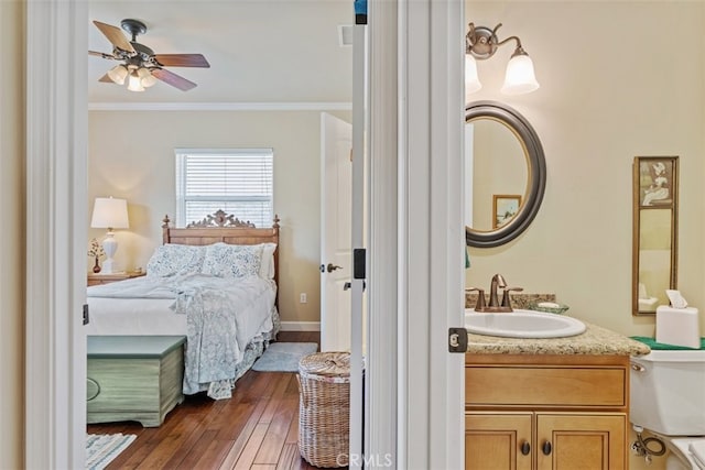 bedroom featuring sink, ceiling fan, ornamental molding, and dark hardwood / wood-style flooring