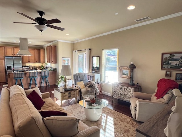 living room with hardwood / wood-style floors, ceiling fan, and ornamental molding