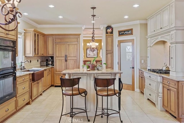 kitchen with light stone countertops, double oven, tasteful backsplash, sink, and hanging light fixtures