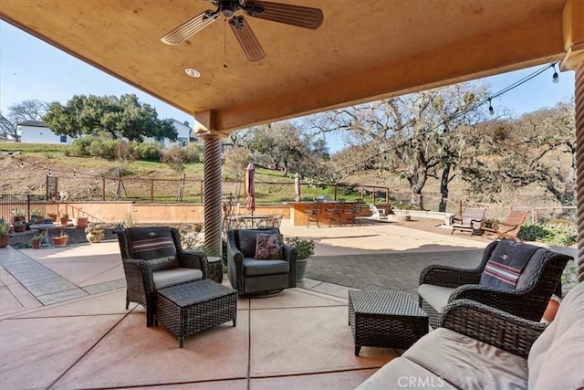 view of patio / terrace featuring a bar, an outdoor living space, and ceiling fan