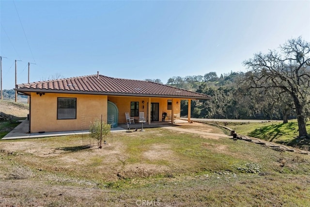 rear view of property featuring a patio area and a yard