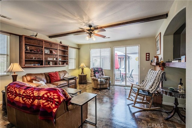 living room featuring beam ceiling, ceiling fan, and a textured ceiling