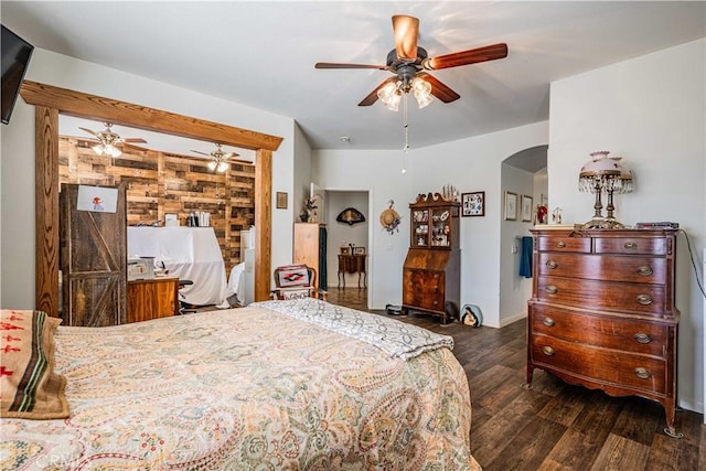 bedroom with dark hardwood / wood-style floors, ceiling fan, and wooden walls