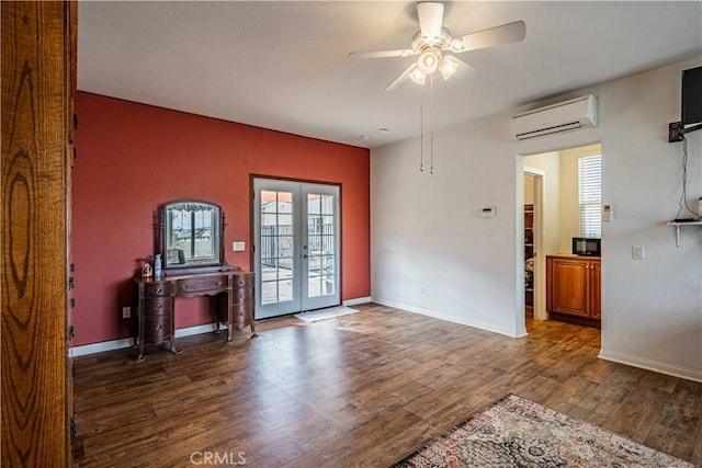 empty room with dark hardwood / wood-style flooring, ceiling fan, french doors, and a wall mounted AC