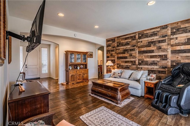 living room featuring dark hardwood / wood-style floors and wooden walls